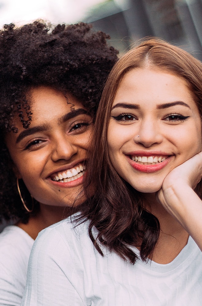 Photo of two young women smiling next to each other